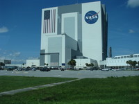 The single-story Vehicle Assembly Building with cars for scale.